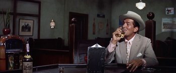 Movie still from “Some Came Running” (1958), directed by Vincente Minnelli – A man sitting at a table with a glass of wine; Close Up shot, Low angle