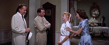 Movie still from “Some Came Running” (1958), directed by Vincente Minnelli – A man and a woman standing next to each other in a room; Medium shot, Over the shoulder angle