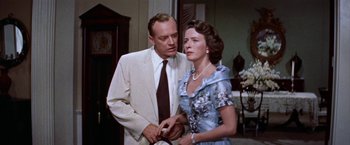 Movie still from “Some Came Running” (1958), directed by Vincente Minnelli – An older man in a suit and tie next to an older woman in a dress; Medium shot, Low angle