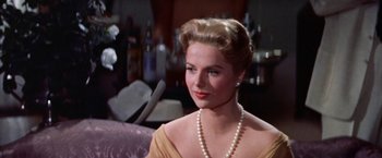 Movie still from “Some Came Running” (1958), directed by Vincente Minnelli – A woman in a yellow dress with a pearl necklace; Close Up shot, Low angle