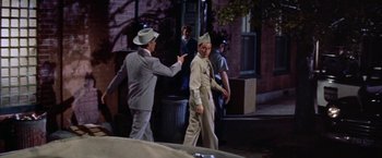 Movie still from “Some Came Running” (1958), directed by Vincente Minnelli – A man in a suit and a hat standing next to another man in a suit; Medium shot, Over the shoulder angle