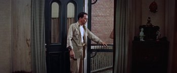Movie still from “Some Came Running” (1958), directed by Vincente Minnelli – A man standing in front of an open door; Medium shot, Low angle