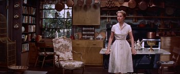 Movie still from “Some Came Running” (1958), directed by Vincente Minnelli – A woman standing in front of an oven in a kitchen; Wide shot, Low angle