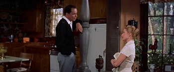 Movie still from “Some Came Running” (1958), directed by Vincente Minnelli – A man and a woman standing next to each other in a kitchen; Medium shot, Low angle