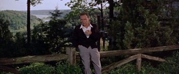 Movie still from “Some Came Running” (1958), directed by Vincente Minnelli – A man standing in a field holding a cell phone; Medium shot, Low angle