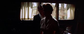 Movie still from “Some Came Running” (1958), directed by Vincente Minnelli – An older woman standing next to a man in front of a window; Medium shot, Low angle