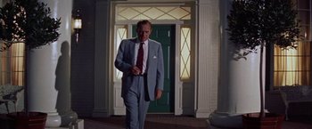 Movie still from “Some Came Running” (1958), directed by Vincente Minnelli – A man in a suit and tie standing in front of a door; Medium shot, Low angle