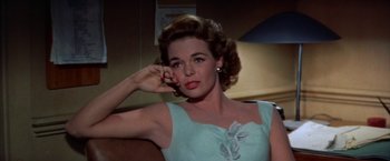 Movie still from “Some Came Running” (1958), directed by Vincente Minnelli – A beautiful woman in a blue dress holding a cell phone to her ear; Close Up shot, Low angle