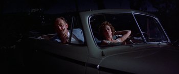 Movie still from “Some Came Running” (1958), directed by Vincente Minnelli – A man and a woman sitting in the back seat of a car; Medium shot, Low angle