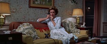 Movie still from “Some Came Running” (1958), directed by Vincente Minnelli – A woman sitting on a couch talking on a phone; Medium shot, High angle