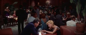 Movie still from “Some Came Running” (1958), directed by Vincente Minnelli – A man and a woman sitting at a table in a restaurant; Wide shot, High angle