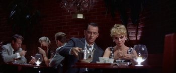 Movie still from “Some Came Running” (1958), directed by Vincente Minnelli – A man and a woman sitting at a table; Medium shot, High angle