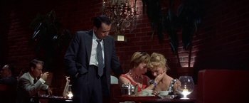 Movie still from “Some Came Running” (1958), directed by Vincente Minnelli – A man and two women sitting at a dinner table; Medium shot, High angle