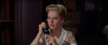 Movie still from “Some Came Running” (1958), directed by Vincente Minnelli – A woman holding a phone up to her ear; Close Up shot, Low angle