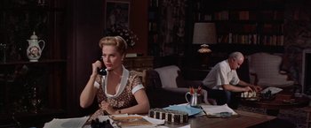 Movie still from “Some Came Running” (1958), directed by Vincente Minnelli – A woman sitting at a table talking on the phone; Medium shot, High angle
