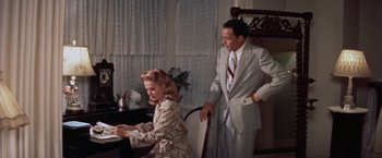 Movie still from “Some Came Running” (1958), directed by Vincente Minnelli – A man and a woman are playing piano in a living room; Medium shot, High angle