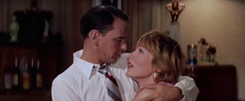 Movie still from “Some Came Running” (1958), directed by Vincente Minnelli – A man and a woman embracing each other in front of a mirror; Close Up shot, Low angle