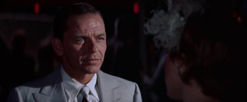 Movie still from “Some Came Running” (1958), directed by Vincente Minnelli – A man in a suit and tie looking at the camera; Close Up shot, Over the shoulder angle
