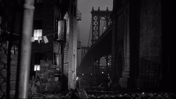 Movie still from “Somebody Up There Likes Me” (1956), directed by Robert Wise – A black and white photo of a bridge in the dark; Wide shot, Low angle