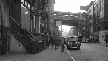 Movie still from “Somebody Up There Likes Me” (1956), directed by Robert Wise – A black and white photo of people walking down a street; Extreme Wide shot, High angle