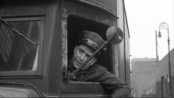 Movie still from “Somebody Up There Likes Me” (1956), directed by Robert Wise – A man wearing a hat is looking out of a train window; Medium shot, Low angle