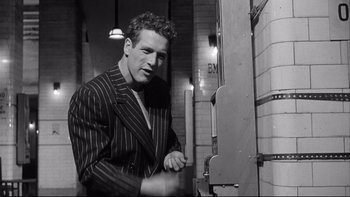 Movie still from “Somebody Up There Likes Me” (1956), directed by Robert Wise – A black and white photo of a man in a suit; Medium shot, Low angle