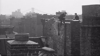 Movie still from “Somebody Up There Likes Me” (1956), directed by Robert Wise – Three men are on the top of a brick wall; Wide shot, High angle