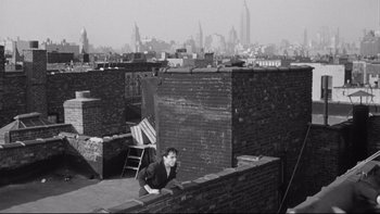 Movie still from “Somebody Up There Likes Me” (1956), directed by Robert Wise – A man leaning on a brick wall on top of a building; Extreme Wide shot, High angle