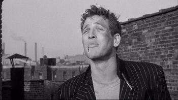 Movie still from “Somebody Up There Likes Me” (1956), directed by Robert Wise – Black and white photograph of a young man smoking a cigarette; Close Up shot, Low angle