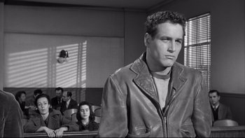 Movie still from “Somebody Up There Likes Me” (1956), directed by Robert Wise – A black and white photo of a man in a courtroom; Medium shot, Over the shoulder angle