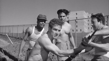 Movie still from “Somebody Up There Likes Me” (1956), directed by Robert Wise – Three shirtless men are playing a game of tennis; Medium shot, Low angle