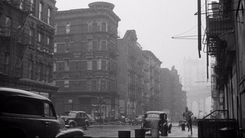Movie still from “Somebody Up There Likes Me” (1956), directed by Robert Wise – A black and white photo of a city street; Extreme Wide shot, Low angle