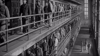 Movie still from “Somebody Up There Likes Me” (1956), directed by Robert Wise – A black and white photo of a group of people in a jail cell; Extreme Wide shot, High angle