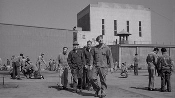Movie still from “Somebody Up There Likes Me” (1956), directed by Robert Wise – A black and white photo of a group of men standing in front of a building; Wide shot, High angle