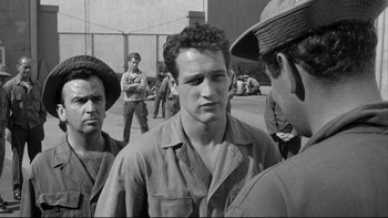 Movie still from “Somebody Up There Likes Me” (1956), directed by Robert Wise – A group of men standing next to each other on a street; Medium shot, Over the shoulder angle
