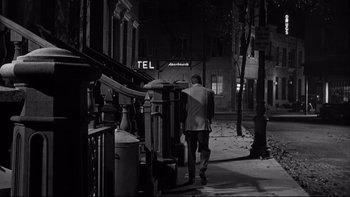 Movie still from “Somebody Up There Likes Me” (1956), directed by Robert Wise – A man walking down a street at night; Wide shot, High angle