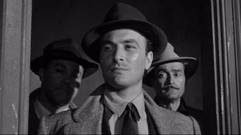 Movie still from “Somebody Up There Likes Me” (1956), directed by Robert Wise – A black and white photo of a man in a suit and hat; Close Up shot, Low angle