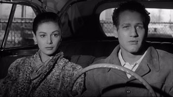 Movie still from “Somebody Up There Likes Me” (1956), directed by Robert Wise – A man and a woman sitting in the back seat of a car; Close Up shot, Low angle