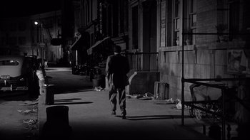 Movie still from “Somebody Up There Likes Me” (1956), directed by Robert Wise – A black and white photo of a man walking down a street; Wide shot, High angle