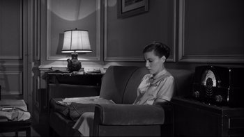 Movie still from “Somebody Up There Likes Me” (1956), directed by Robert Wise – A boy sitting in a chair in front of a lamp; Medium shot, High angle