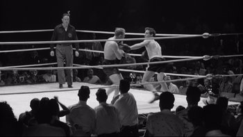 Movie still from “Somebody Up There Likes Me” (1956), directed by Robert Wise – Two men in a boxing ring fighting in front of a crowd; Wide shot, High angle