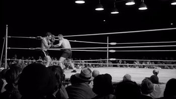 Movie still from “Somebody Up There Likes Me” (1956), directed by Robert Wise – Two men are boxing in a boxing ring while spectators watch; Wide shot, High angle