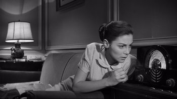 Movie still from “Somebody Up There Likes Me” (1956), directed by Robert Wise – A woman laying on a couch in a living room; Medium shot, High angle