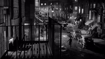 Movie still from “Somebody Up There Likes Me” (1956), directed by Robert Wise – A man walking down a street at night; Extreme Wide shot, High angle