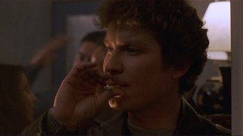Movie still from “Someone to Watch Over Me” (1987), directed by Ridley Scott – A person smoking a cigarette; Close Up shot, Low angle