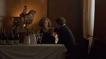 Movie still from “Someone to Watch Over Me” (1987), directed by Ridley Scott – A man and a woman sitting at a dinner table; Medium shot, Over the shoulder angle