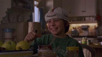 Movie still from “Someone to Watch Over Me” (1987), directed by Ridley Scott – A young boy wearing a paper hat and eating a sandwich; Close Up shot, Low angle