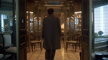 Movie still from “Someone to Watch Over Me” (1987), directed by Ridley Scott – A man is standing in a room full of chairs; Wide shot, Low angle