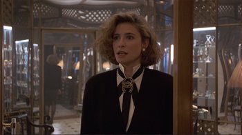 Movie still from “Someone to Watch Over Me” (1987), directed by Ridley Scott – A woman in a suit and tie standing in front of a wall; Close Up shot, Over the shoulder angle