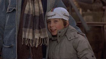 Movie still from “Someone to Watch Over Me” (1987), directed by Ridley Scott – A young boy wearing a cap and a jacket; Close Up shot, Over the shoulder angle